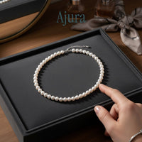 Ajura Pearls classic off-round freshwater pearl choker necklace with adjustable clasp. Available in white, peach, and lavender.