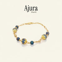 Ajura Pearls bracelet with dark grey freshwater pearls and gold-plated filigree beads. Adjustable length.