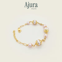 Ajura Pearls bracelet with pink and lavender freshwater pearls, gold-plated chain and decorative bead caps.