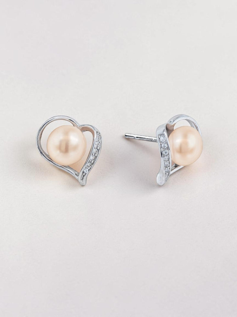 Ajura Pearls peach freshwater pearl stud earrings in sterling silver heart setting with small crystals.