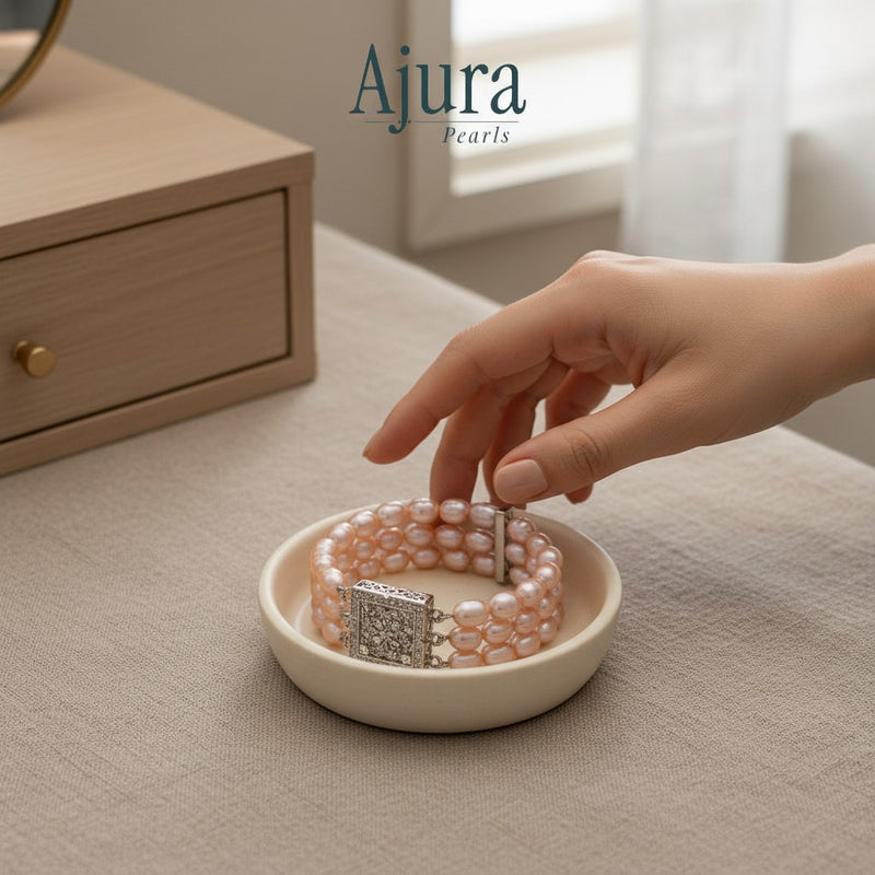 Ajura Pearls three-strand bracelet with natural pink rice pearls and a decorative silver clasp.