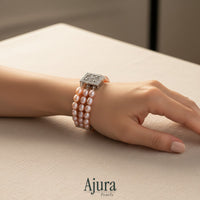 Ajura Pearls three-strand bracelet with natural pink rice pearls and a decorative silver clasp.